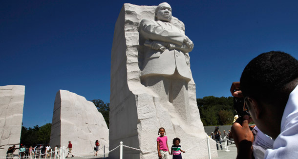 Christopher Ogden, of Charlotte, right, takes a photograph of his  children, Courtney Ogden, 6, center, and Conrad Ogden, 2, with a statue  of Dr. Martin Luther King, Jr. at the Martin Luther King, Jr. Memorial  in Washington on August 22, 2011.  The memorial will be officially  dedicated on Sunday. (AP/Jacquelyn Martin)