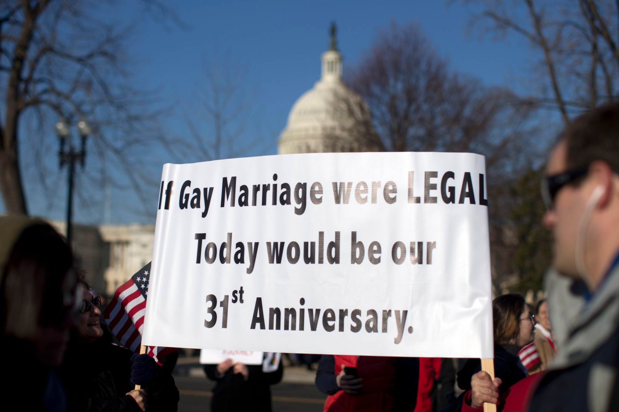 With the Capitol in the background, supporters of gay marriage carry signs in front of the Supreme Court before the Court heard arguments on the Defense of Marriage Act, or DOMA. (AP/Carolyn Kaster)