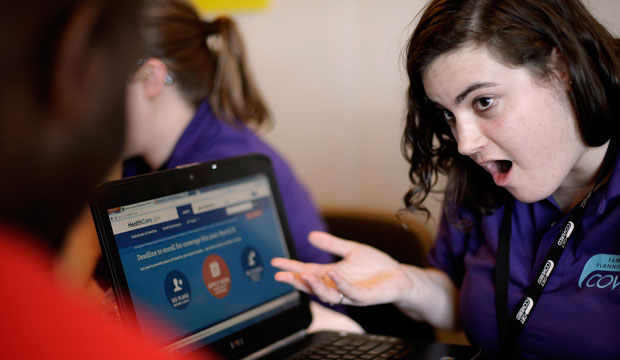 Elizabeth Rich helps a man sign up for the Affordable Care Act at Swope Health Services in Kansas City, Missouri. (AP/Charlie Riedel)