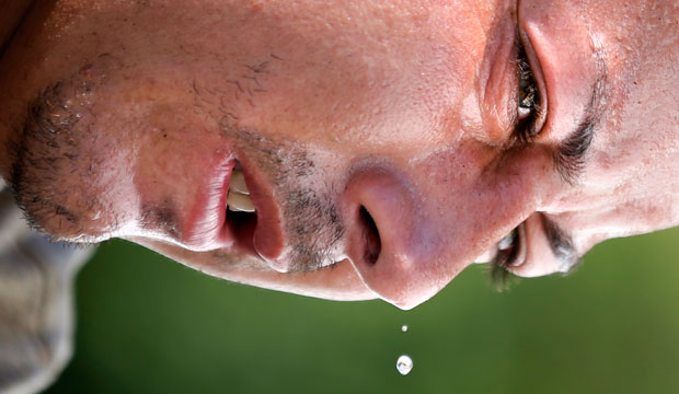 Juan Belis sweats as he works in the midday heat. Global warming is rapidly turning America the beautiful into America the dangerous according to the National Climate Assessment report. (AP/Matt Rourke)