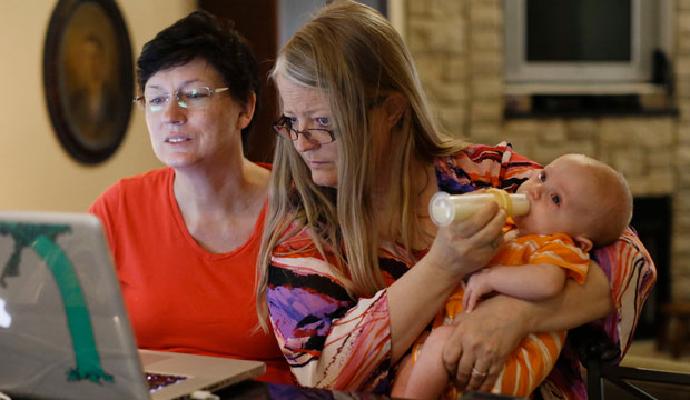 Julia Tate, left, sits with her wife, Lisa McMillin, on June 26, 2013, in Nashville, Tennessee. McMillin holds the couple's son, Luke. (AP/Mark Humphrey)