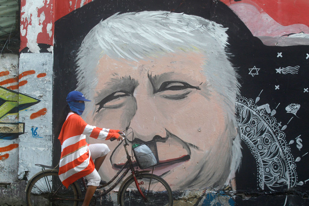 A woman rides her bicycle past a mural of Donald Trump in Surabaya, East Java, Indonesia, November 9, 2016. (AP/Trisnadi)