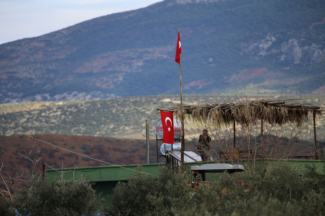 People hang Turkish flags in Sugedigi neighbourhood of Hassa district in Hatay, Turkey, on January 19, 2018. (Getty/Cem Genco/Anadolu Agency)