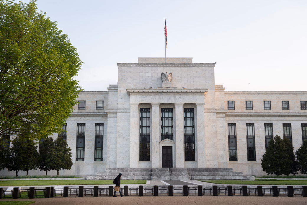 A person walks by the Federal Reserve building in Washington, D.C., on April 25, 2020. (Getty/Caroline Brehman/CQ-Roll Call Inc.)