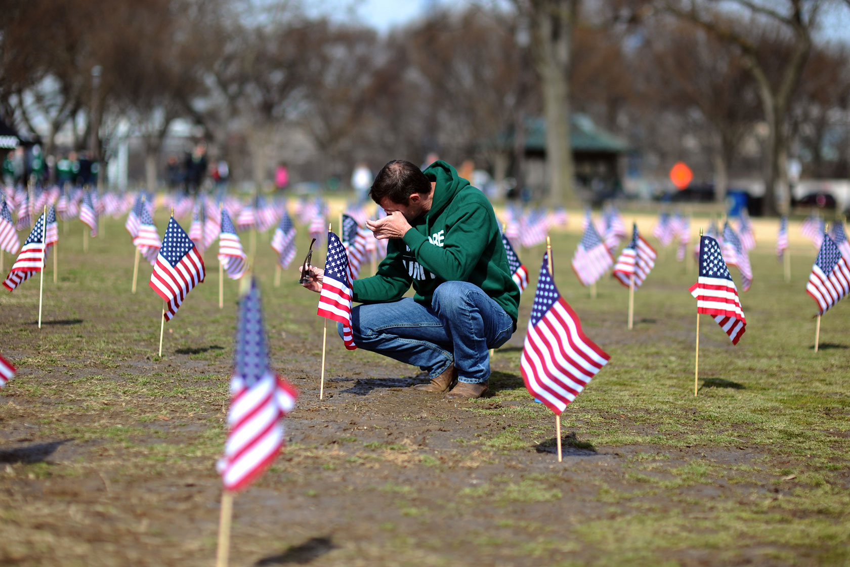 A war veteran helps set up American flags on the National Mall.
