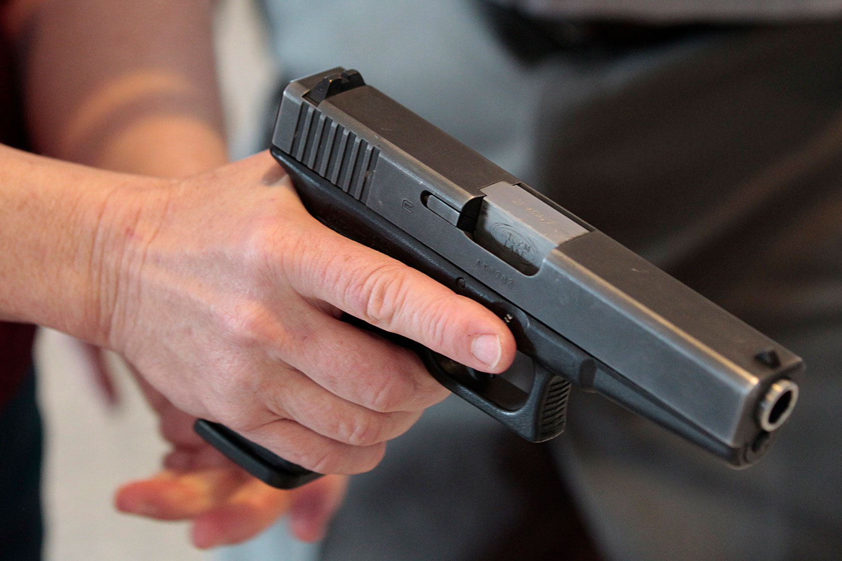 Photo shows a hand holding a handgun.