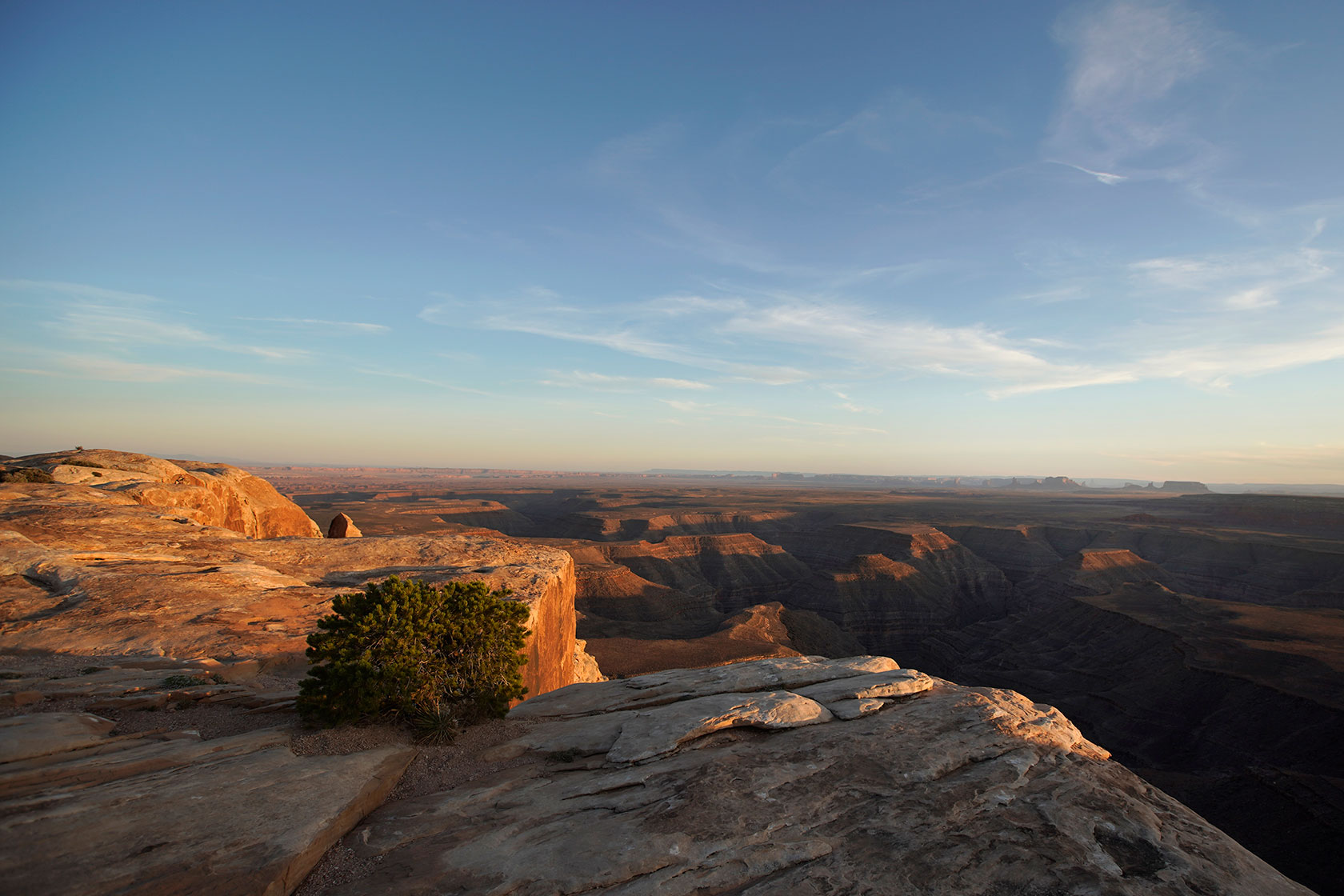 Photo shows the sun setting over a canyon landscape in Utah.