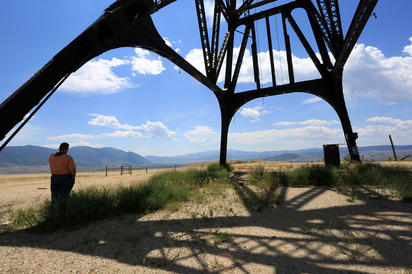 A reclamation inspector takes a call while standing under a gallows frame located near the Berkeley Pit.