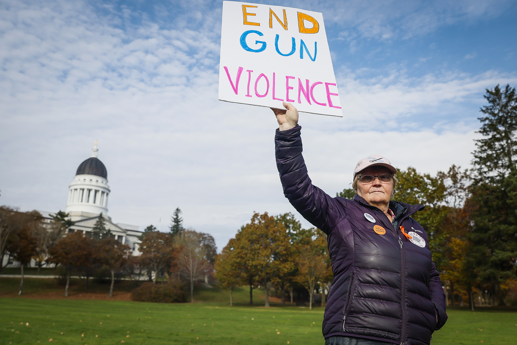 Woman outdoors, holding up sign that reads 