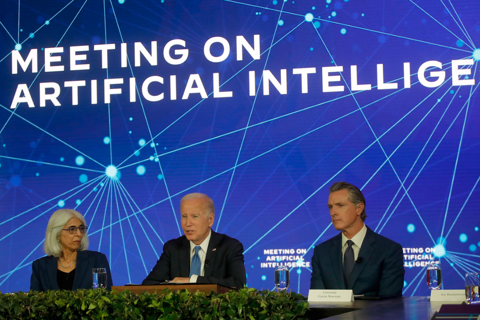 President Joe Biden sits at a table with California Gov. Gavin Newsom (D) to the right Arati Prabhakar to the left.