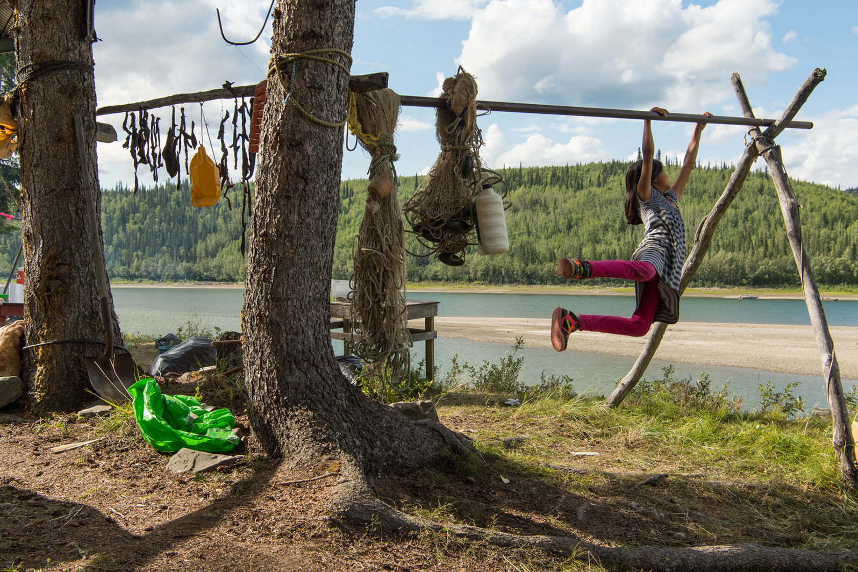 Child swings from a fish drying rack
